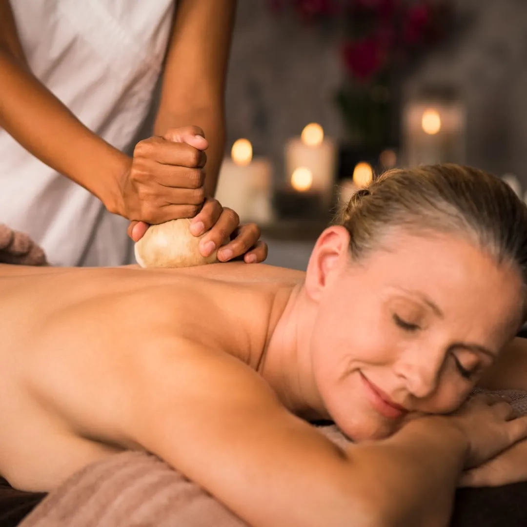 Ayurvedic doctor examining patient's lower back during back pain consultation at Vedara Care JVC Dubai