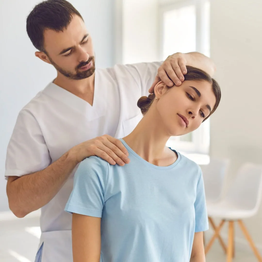 Physiotherapist assessing patient neck pain at Vedara Care JVC Dubai clinic